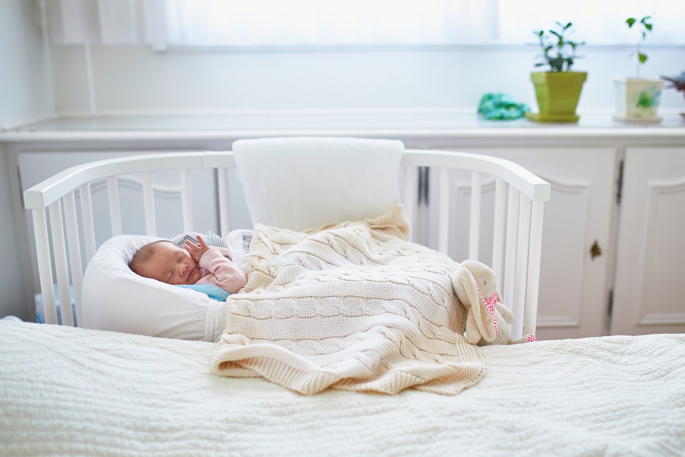 Newborn Baby Sleeping in Co-Sleeper Crib Near the Bed