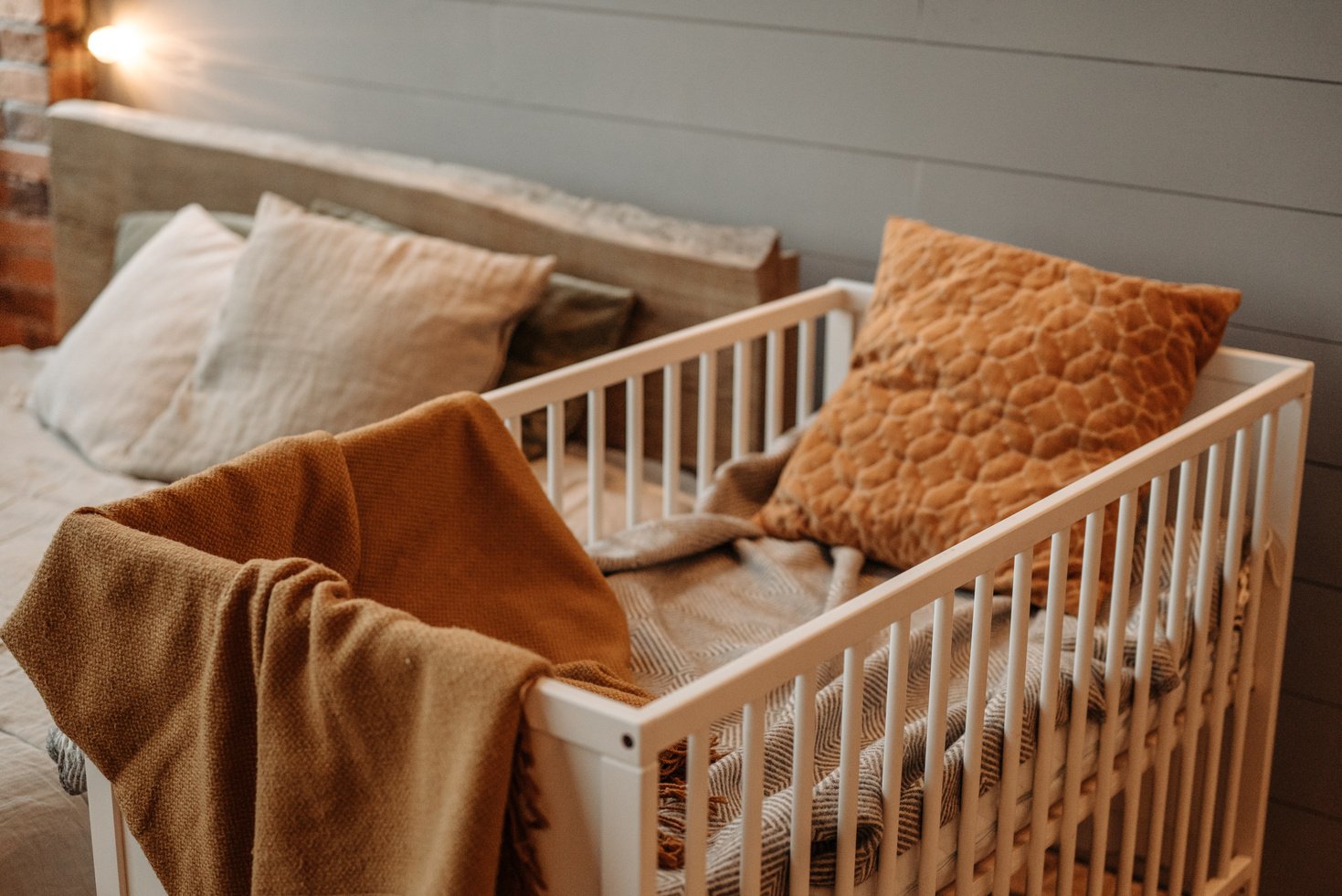 Brown Blanket and Pillow on White Wooden Crib 