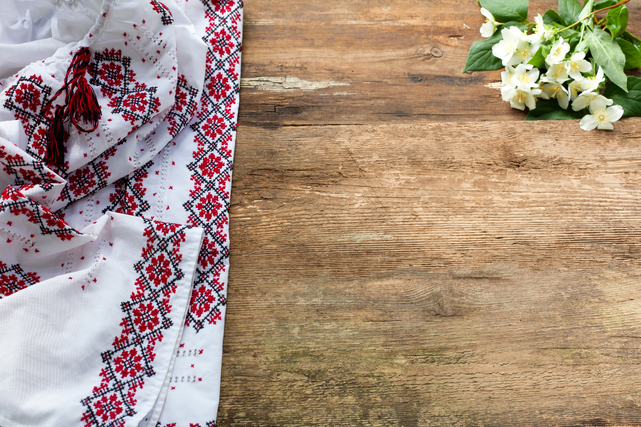 Ukrainian clothes embroidered white shirt on wooden background. Vyshyvanka is a symbol of Ukraine. Copy space.